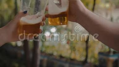 <strong>双手拿</strong>着透明的塑料杯，喝着淡啤酒，干杯